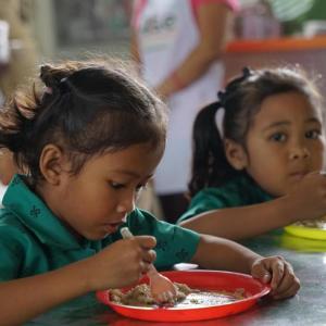 Two children eating at a table.