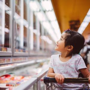 A child seated in a shopping at looking at items