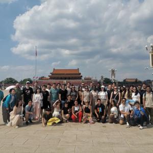 A large group posed outside, a palace in the background.