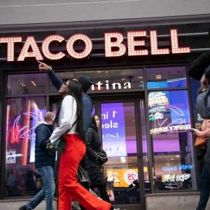 People walking by a Taco Bell