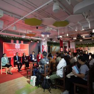 People seated in front of a room of others.