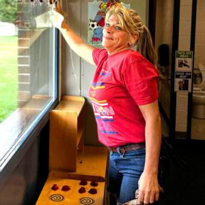 a person cleaning a window in a kids classroom