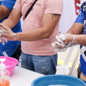 people cleaning hands in small basins