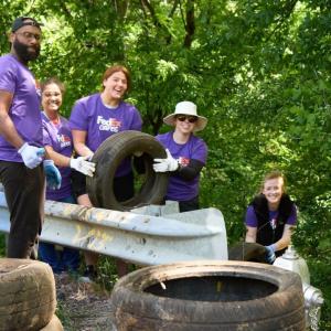 Volunteers pulling used tires out of the forested area.