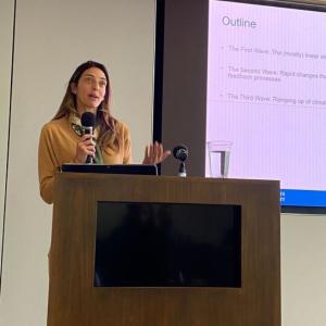 speaker holding a microphone behind a podium