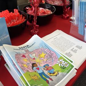 A children's book on a decorated table with treats and pamphlets.