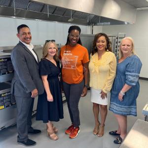 A group of five posed inside the kitchen of the facility.