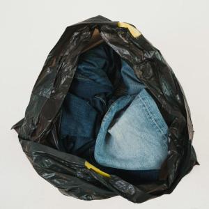 A black garbage bag with jeans inside