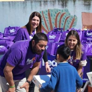 Volunteers handing a box to a child