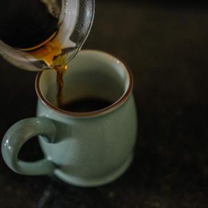 Coffee is poured into a mug from a carafe.
