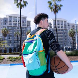 Person with a colorful "Project UP" backpack holding a basketball