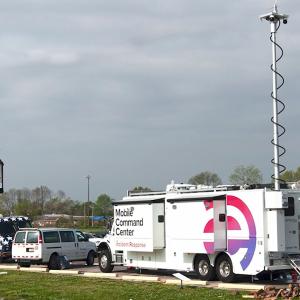 A truck with Entergy logo and Mobile Command Center on the side, antenna raised, parked in a parking lot.