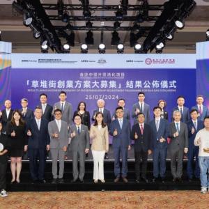 Large group assembled on stage. Some members are holding awards.