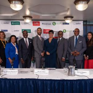A line of people posed behind a long desk.