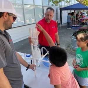 An employee showing attendees a display.