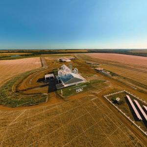 Aerial view of a farm in a very large crop field.