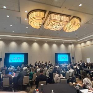 Conference room filled with people at tables and chairs