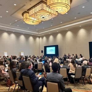 Conference room filled with people at tables and chairs