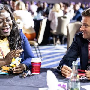 Two people talking at a table at the conference