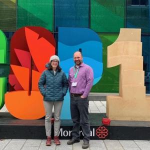 Two people in front of a COP 15 sign