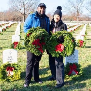 two people standing with wreaths 