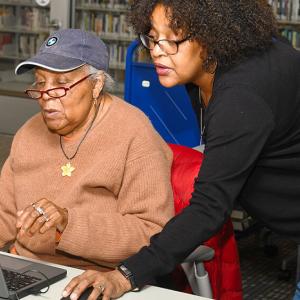 One person teaching another computer skills