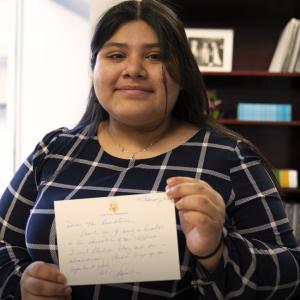 Llulisa, an Internet Essentials customer since freshman year of high school, holding up a hand written letter