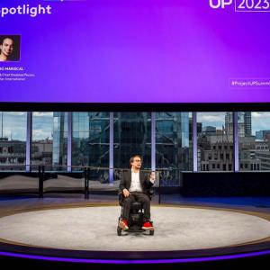 Man in wheelchair talking on stage 