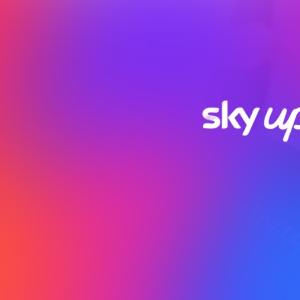 Photo of person on a laptop with colorful overlay and text: sky up, Spectra