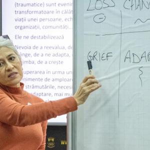 A person pointing to "grief" written on a board.