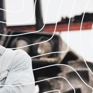 A person outside in front of a tractor.