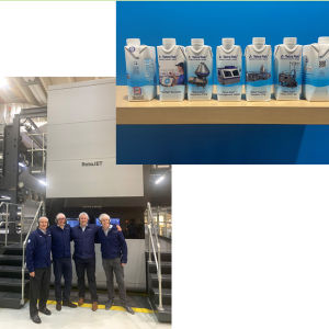 A group of four people in front of a large machine and a picture of cartons of milk.
