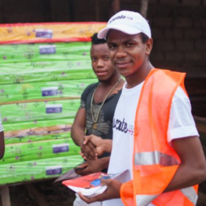 Three people outside standing and talking. One with a high-vis vest.