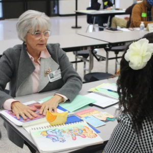 Retired GP employee Deborah Baker talking with a student