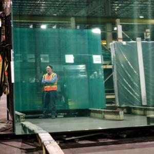 Dean standing by large sheets of glass.