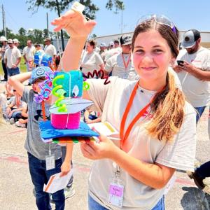 A person holding up a colorful handmade item