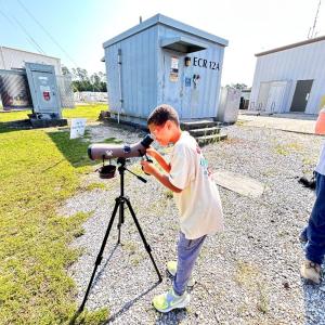 a child looking through a scope
