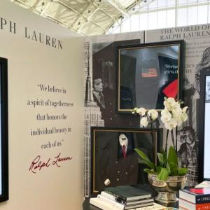 A display of "Ralph Lauren". Digital screens on the walls and a staged desk.