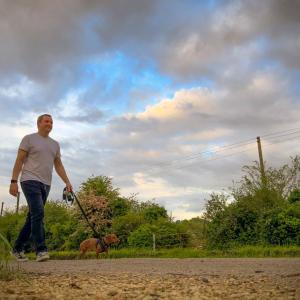 A person walking a dog outside.