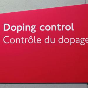 A red sign "Doping control" and an arrow pointing left.