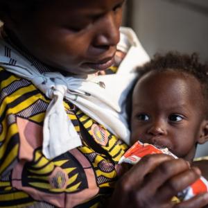A mother feeds her young child Plumpy'Nut, the peanut butter-like paste used to treat malnutrition.