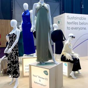 Manequins in different dresses. A display "Sustainable textiles belong to everyone." behind them.