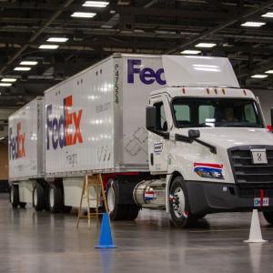 a large FedEx truck parked behind cones in a driving facility
