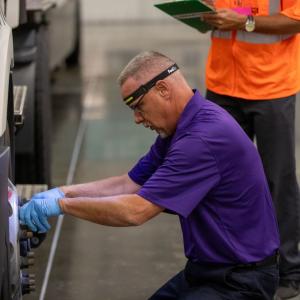 fedex driver working on a wheel of a truck