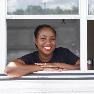 Amber Tellis of Kaylee’s Cake Pops and More leaning out a window