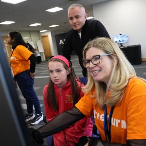 Adults and a child looking at a screen