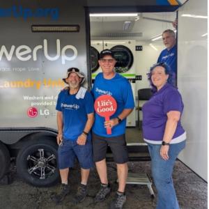 People smiling outside a ShowerUp mobile laundry unit