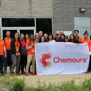 A group of employees posed outside with a "Chemours" banner.