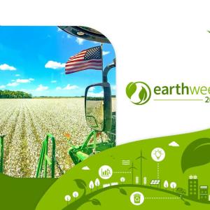 "earth week 2024" next to an american flag on a tractor in a field of crops.