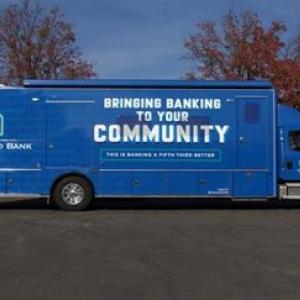 A semi trailer in all blue with "Bringing banking to your community" on the side with 5/3 logo.